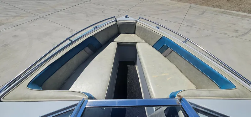 Slide: The Image of 1989 Galaxie 1900 Starion boat interior with blue and gray seating, docked on concrete. - 8