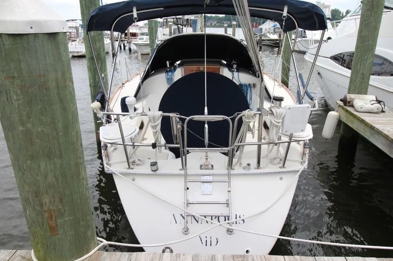 Slide: The Image of 1989 Pearson 39-2 sailboat docked at marina, rear view with blue canopy. - 2