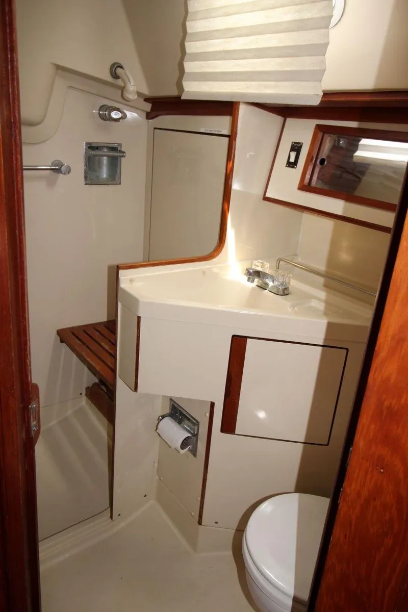 Slide: The Image of 1989 Pearson 39-2 yacht bathroom with sink, toilet, and wooden accents. - 23