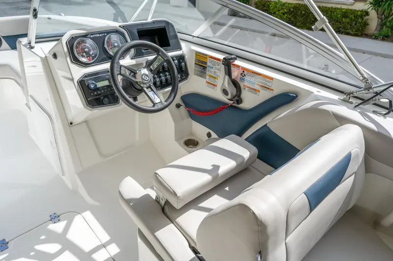 Slide: The Image of 2025 Hurricane SunDeck 2050 OB boat interior with steering wheel and dashboard controls. - 9