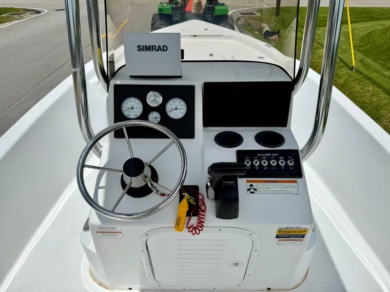 Slide: The Image of 2019 Blazer Bay 1900 boat console with steering wheel, gauges, and Simrad display. - 11