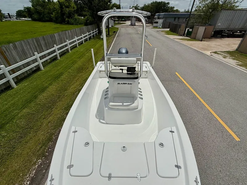 Slide: The Image of 2019 Blazer Bay 1900 boat on road, showcasing deck and console. - 16