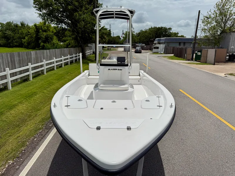 Slide: The Image of 2019 Blazer Bay 1900 boat on road, surrounded by greenery and fences. - 6