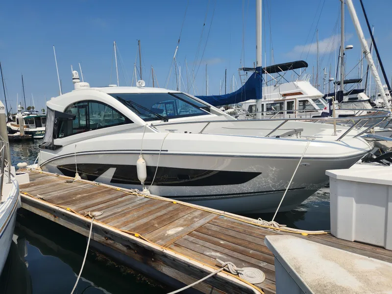 Slide: The Image of 2023 Beneteau GT32 yacht docked at a marina under clear blue skies. - 1