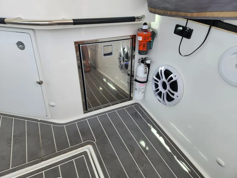 Slide: The Image of 2023 Beneteau GT32 boat interior with speaker, fire extinguisher, and storage compartment. - 16
