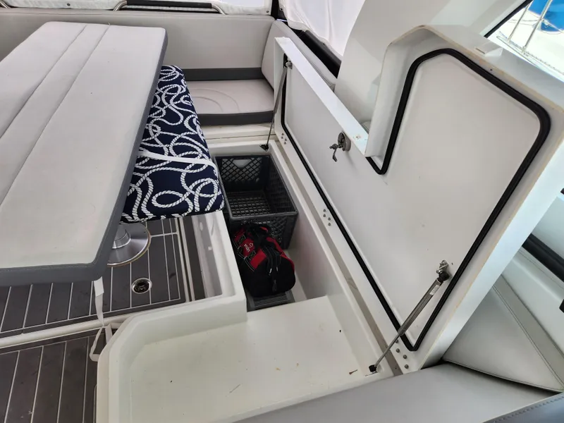 Slide: The Image of 2023 Beneteau GT32 boat interior with open storage compartment and seating area. - 20