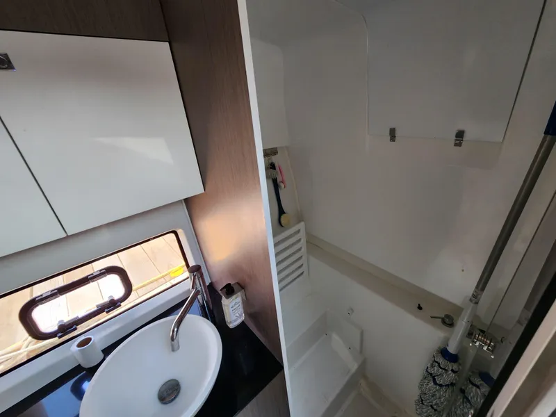 Slide: The Image of 2023 Beneteau GT32 yacht bathroom with sink, window, and storage cabinet. - 25
