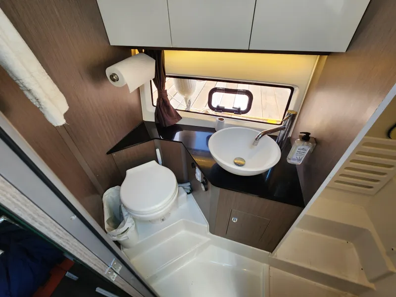 Slide: The Image of 2023 Beneteau GT32 yacht bathroom with modern sink, toilet, and window. - 26