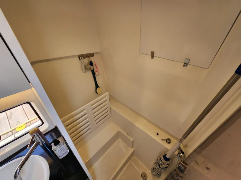 Slide: The Image of Interior of 2023 Beneteau GT32 boat bathroom with sink and cleaning supplies. - 27