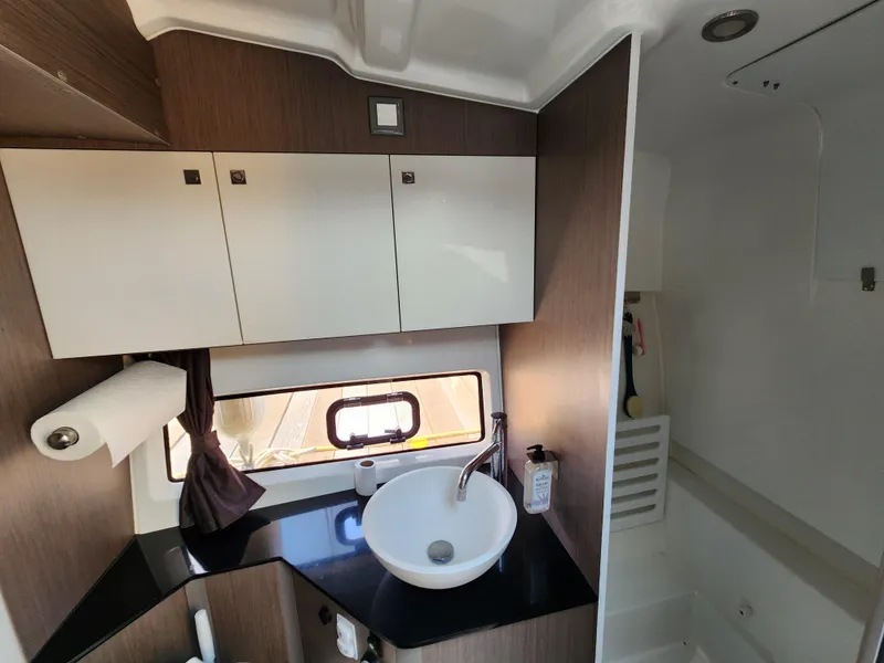 Slide: The Image of 2023 Beneteau GT32 bathroom interior with sink, cabinets, and window. - 28