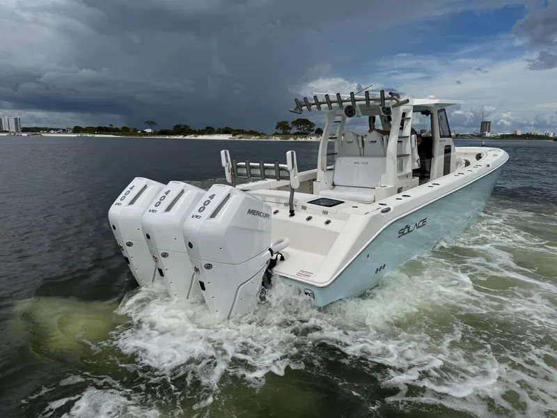 Slide: The Image of 2026 Solace 37 CS boat with triple Mercury engines on water under cloudy sky. - 11