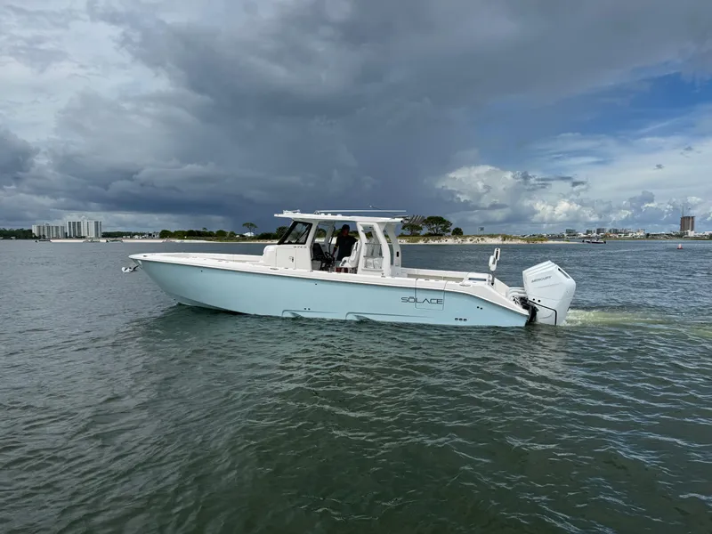 Slide: The Image of 2026 Solace 37 CS boat cruising on a calm waterway under a cloudy sky. - 3