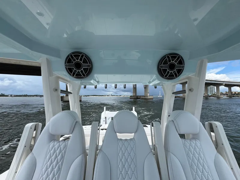 Slide: The Image of 2026 Solace 37 CS boat interior with stylish seating and speakers, cruising under a bridge. - 37