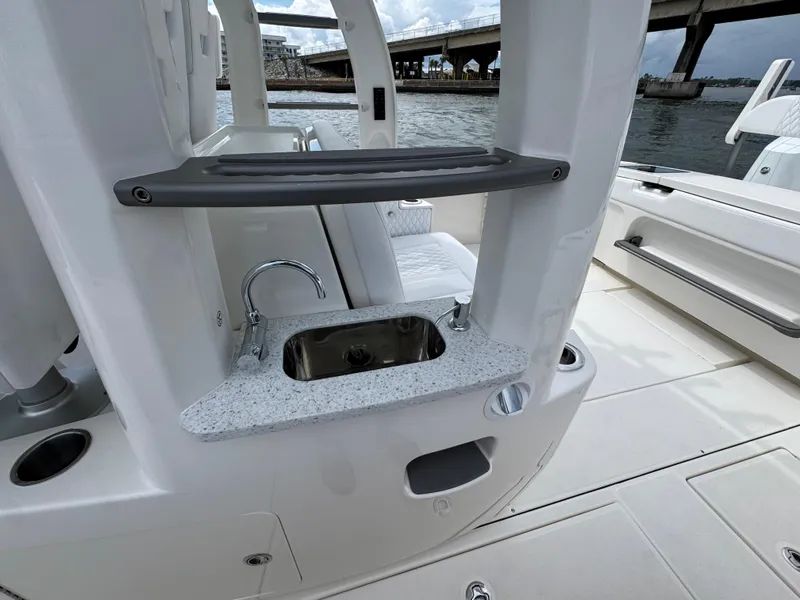 Slide: The Image of Luxury boat Solace 37 CS 2026 with sleek sink and countertop, docked near a bridge. - 41