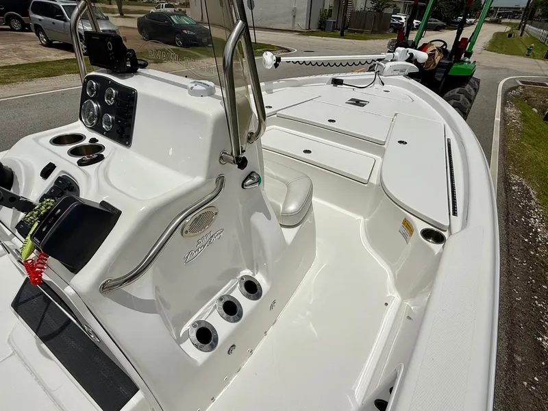 Slide: The Image of 2017 Blue Wave 2000 PureBay boat interior with console and seating, parked on a street. - 14
