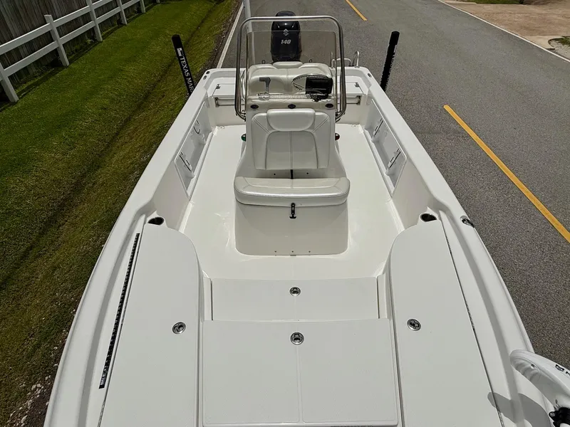 Slide: The Image of 2017 Blue Wave 2000 PureBay boat interior with seating and console on a road. - 15