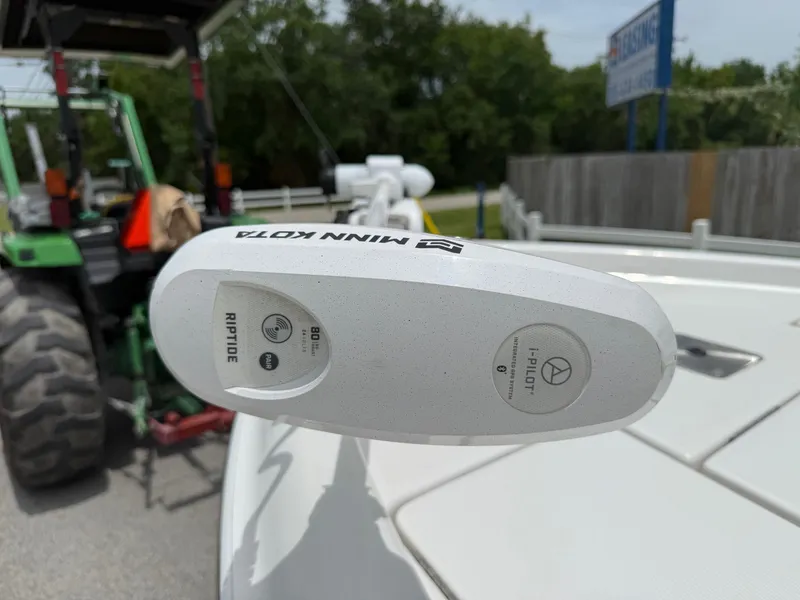 Slide: The Image of Minn Kota Riptide motor on 2017 Blue Wave 2000 PureBay boat, with tractor in background. - 17