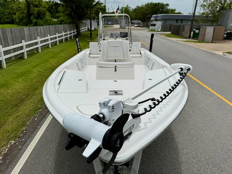 Slide: The Image of 2017 Blue Wave 2000 PureBay boat on road, featuring trolling motor and spacious deck. - 6