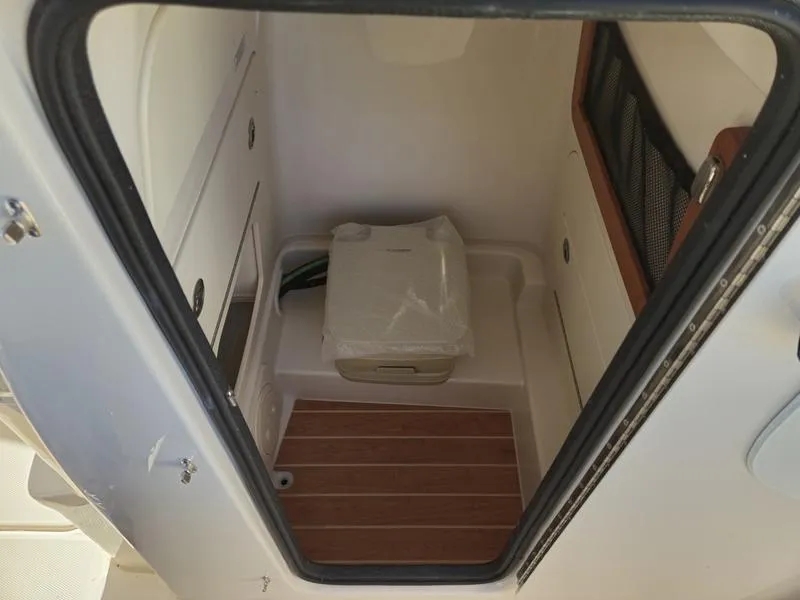 Slide: The Image of 2025 Grady-White Fisherman 236 boat interior with storage compartment and wooden flooring. - 10