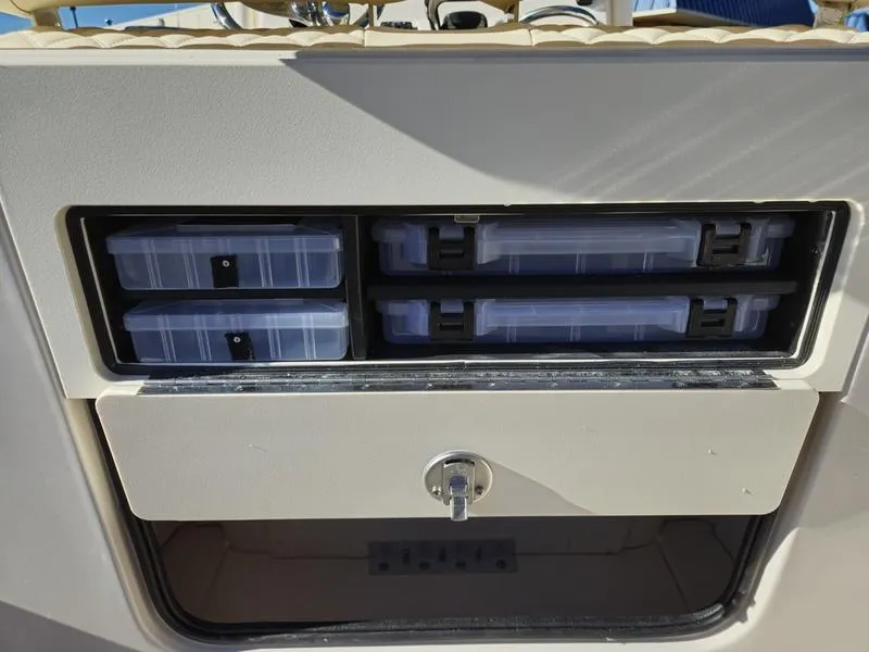 Slide: The Image of 2025 Grady-White Fisherman 236 storage compartment with organized tackle boxes. - 13