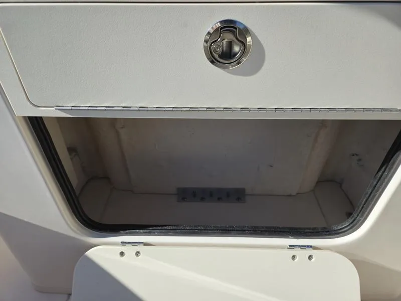 Slide: The Image of Storage compartment on a 2025 Grady-White Fisherman 236 boat, featuring a secure latch. - 8
