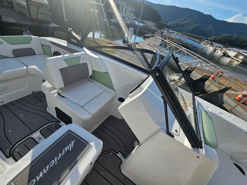 Slide: The Image of 2025 Hurricane SD2050-OB boat interior with seating, docked by a scenic lake. - 13