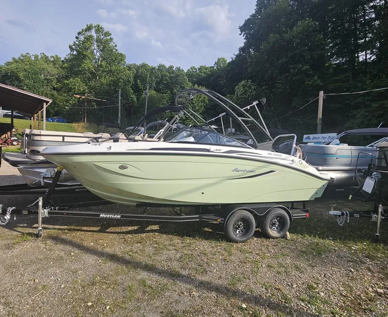 Slide: The Image of 2025 Hurricane SD2050-OB boat on trailer, parked outdoors with trees in background. - 2