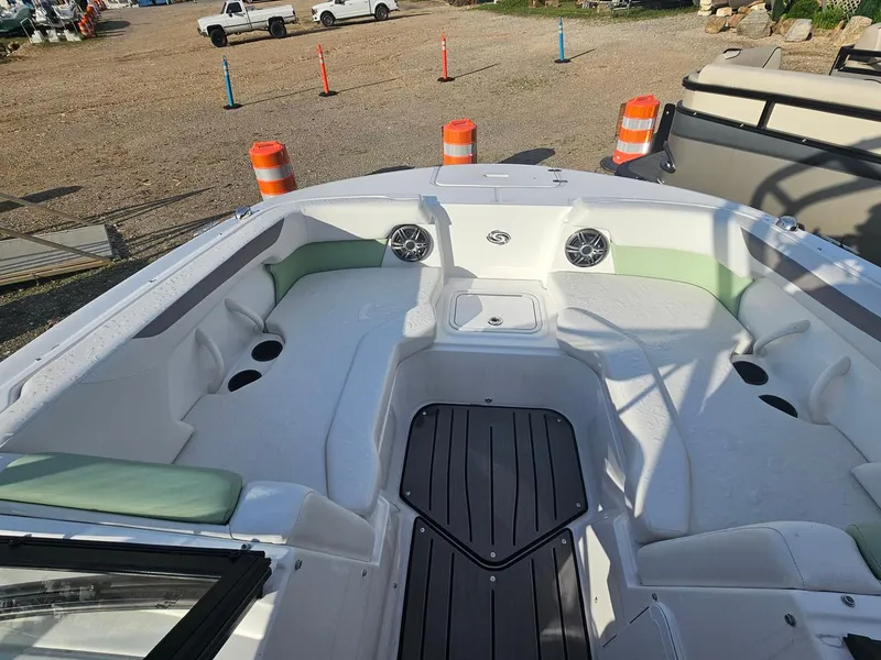 Slide: The Image of 2025 Hurricane SD2050-OB boat interior with seating and cup holders, parked outdoors. - 4