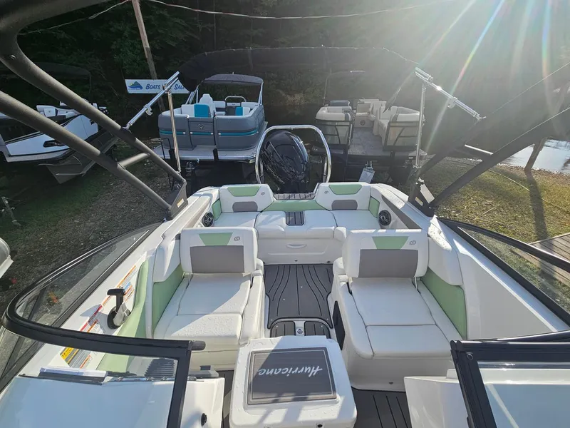 Slide: The Image of 2025 Hurricane SD2050-OB boat interior with white and green seating, docked under sunlight. - 7