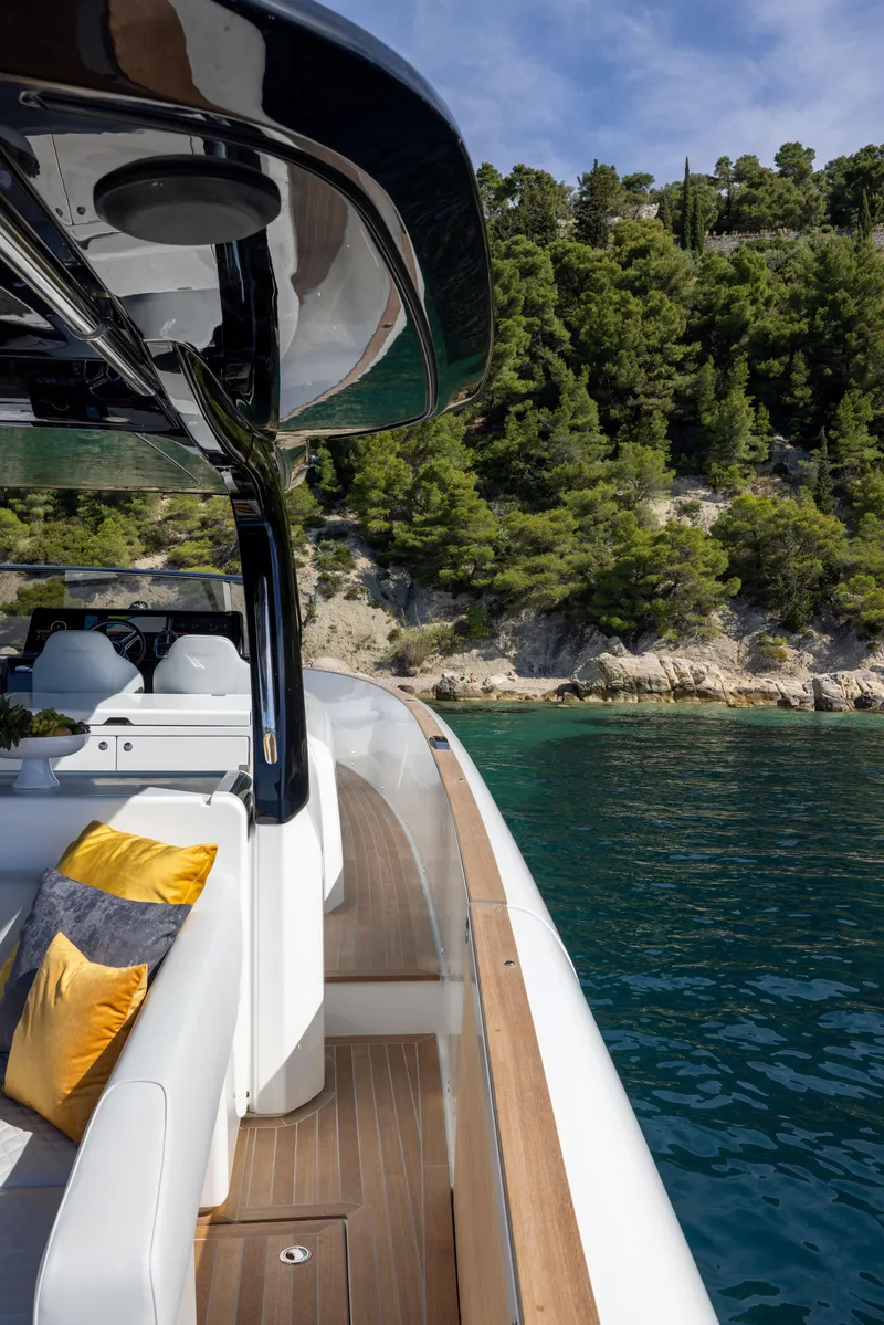 Slide: The Image of 2025 Solaris Power 60 Open yacht with luxurious seating, cruising near a lush, green coastline. - 16