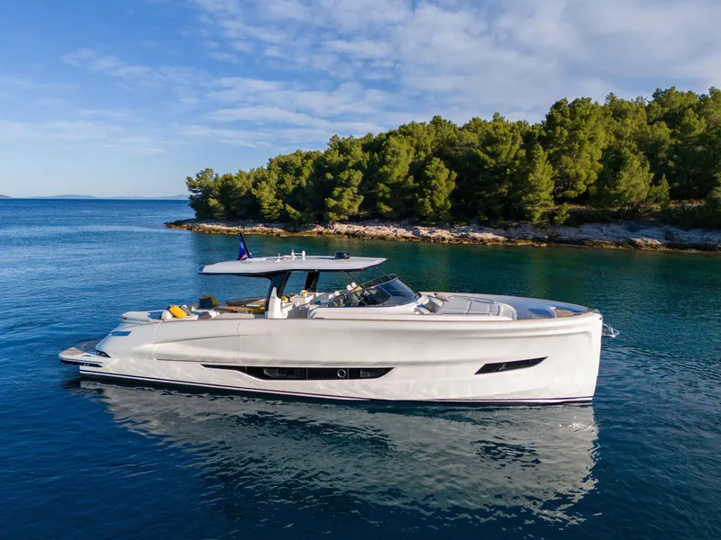 Slide: The Image of 2025 Solaris Power 60 Open luxury yacht cruising near a forested coastline. - 21