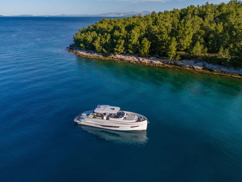 Slide: The Image of 2025 Solaris Power 60 Open yacht cruising near a lush, green coastline. - 24