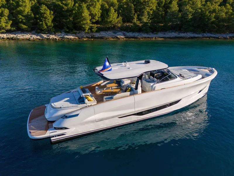 Slide: The Image of Solaris Power 60 Open 2025 luxury yacht cruising on clear blue water near a forested shoreline. - 3