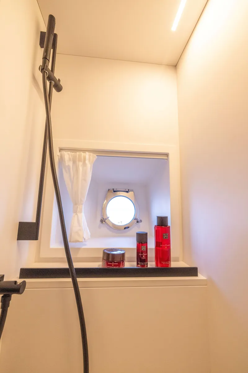 Slide: The Image of Modern bathroom on Solaris Power 60 Open yacht, 2025 model, featuring a sleek shower and porthole window. - 42