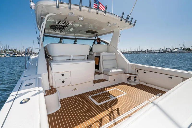 Slide: The Image of 2001 Tiara Yachts 3800 with spacious deck, white seating, and wood flooring on a sunny day. - 16