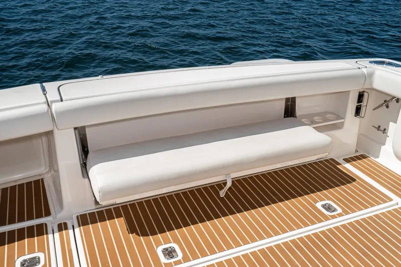 Slide: The Image of 2001 Tiara Yachts 3800 with white seating and teak deck, overlooking the ocean. - 20