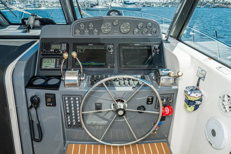 Slide: The Image of Helm of 2001 Tiara Yachts 3800 with navigation instruments and steering wheel, overlooking marina. - 26
