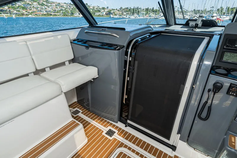 Slide: The Image of Interior of 2001 Tiara Yachts 3800, featuring seating and helm area with water view. - 28