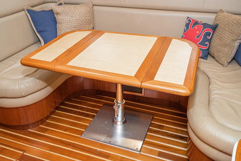 Slide: The Image of Interior of 2001 Tiara Yachts 3800 with wooden table and cushioned seating. - 39