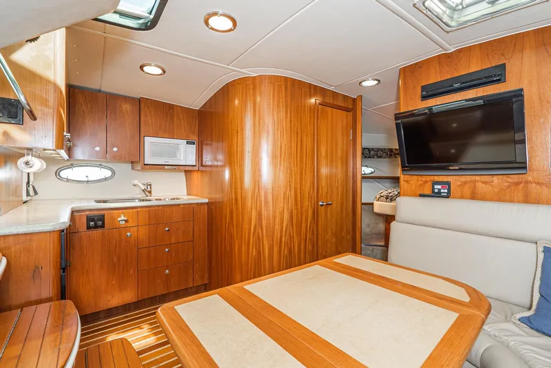 Slide: The Image of Interior of 2001 Tiara Yachts 3800, featuring wood cabinetry, kitchenette, and seating area. - 41