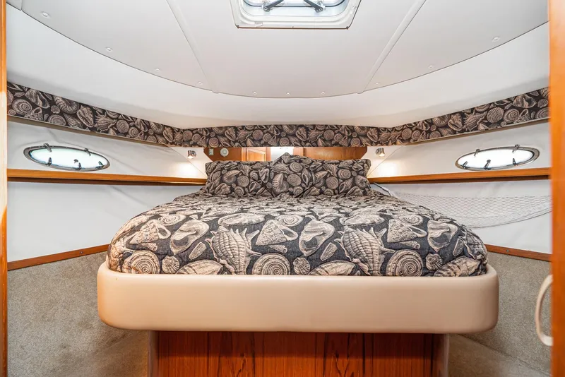 Slide: The Image of Luxurious cabin interior of 2001 Tiara Yachts 3800 with patterned bedding and elegant design. - 46