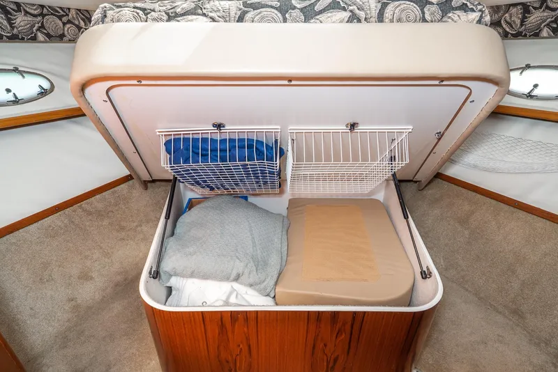 Slide: The Image of Storage compartment in a 2001 Tiara Yachts 3800, featuring organized bedding and cushions. - 47