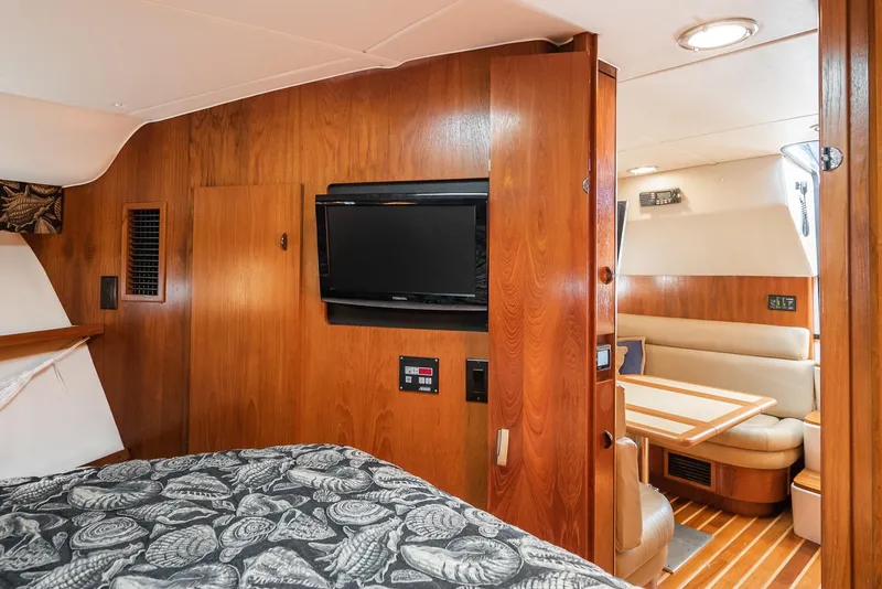 Slide: The Image of Interior of 2001 Tiara Yachts 3800, featuring wood paneling, TV, and cozy seating area. - 49