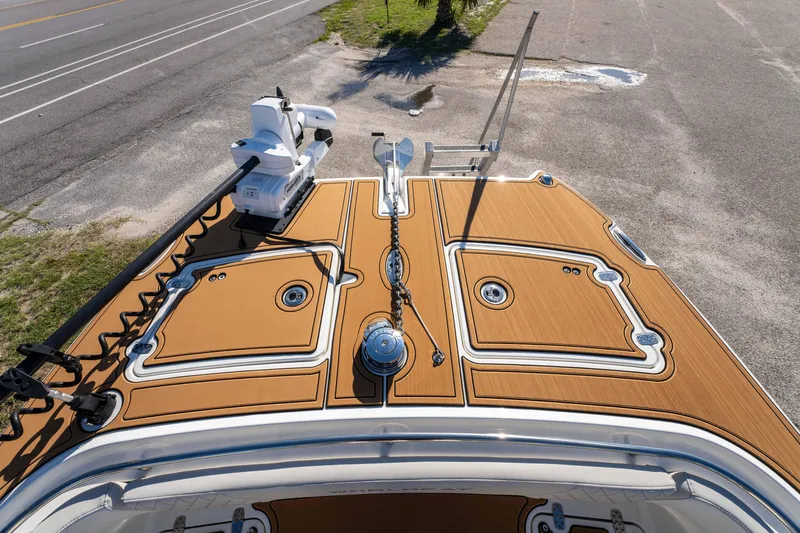 Slide: The Image of 2024 World Cat 260 CC-X boat deck with tan and white detailing, parked on pavement. - 26