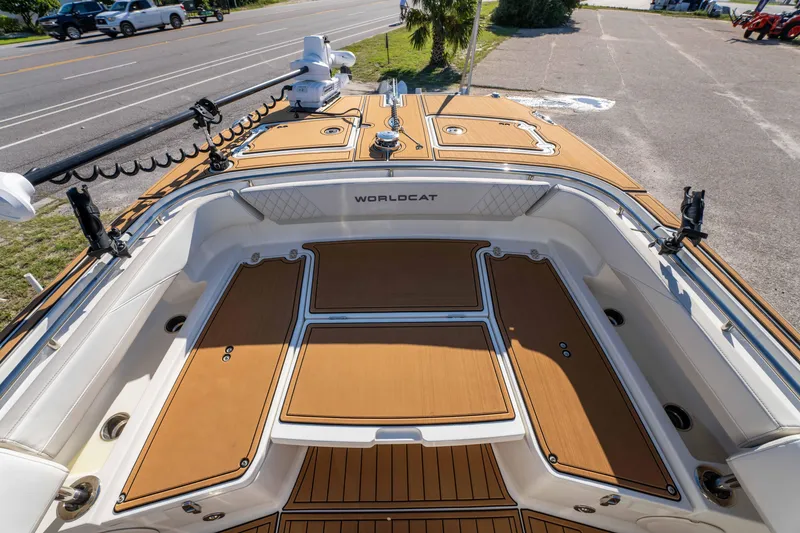Slide: The Image of 2024 World Cat 260 CC-X boat deck with tan flooring and fishing rod holders. - 32