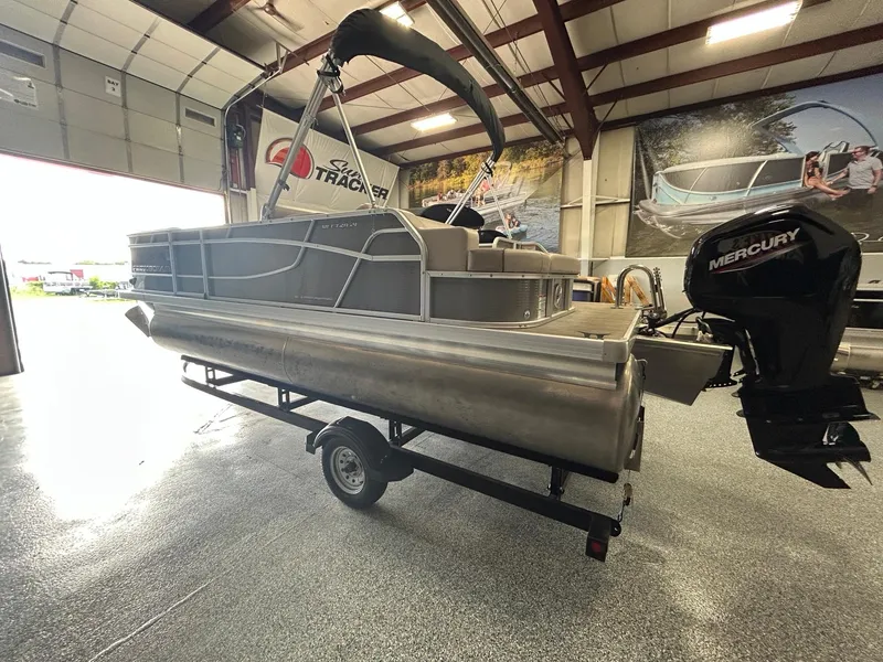Slide: The Image of 2020 Princecraft Vectra 21 pontoon boat in showroom with Mercury outboard motor. - 2