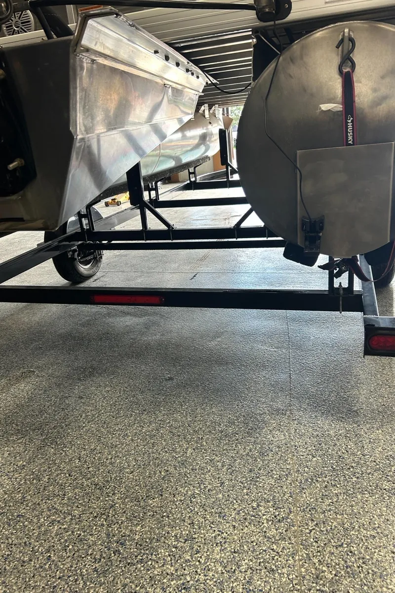 Slide: The Image of 2020 Princecraft Vectra 21 pontoon boat on a trailer, showing underside and wheels. - 20