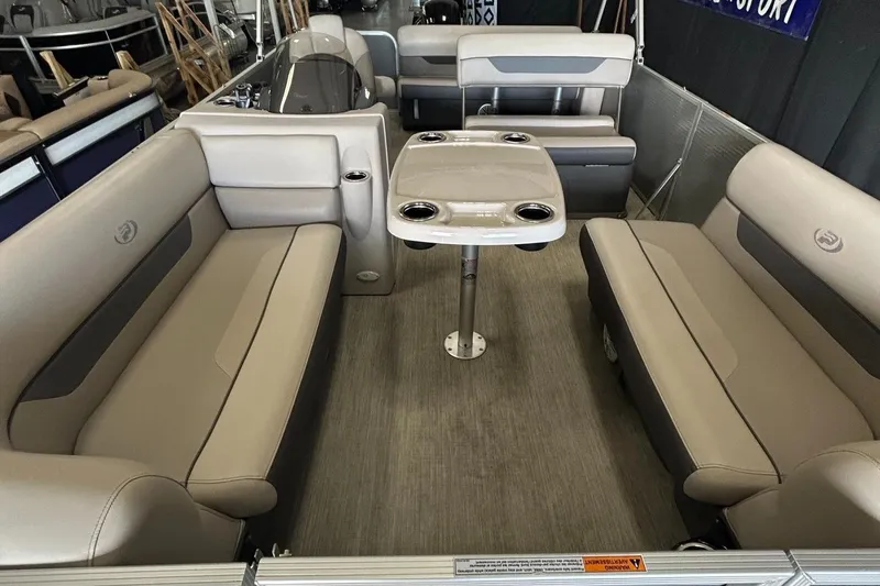 Slide: The Image of 2020 Princecraft Vectra 21 pontoon boat interior with beige seating and central table. - 22
