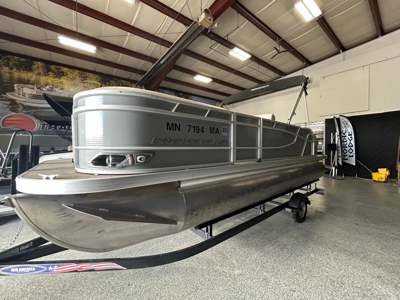 Slide: The Image of 2020 Princecraft Vectra 21 pontoon boat displayed indoors on a trailer. - 4