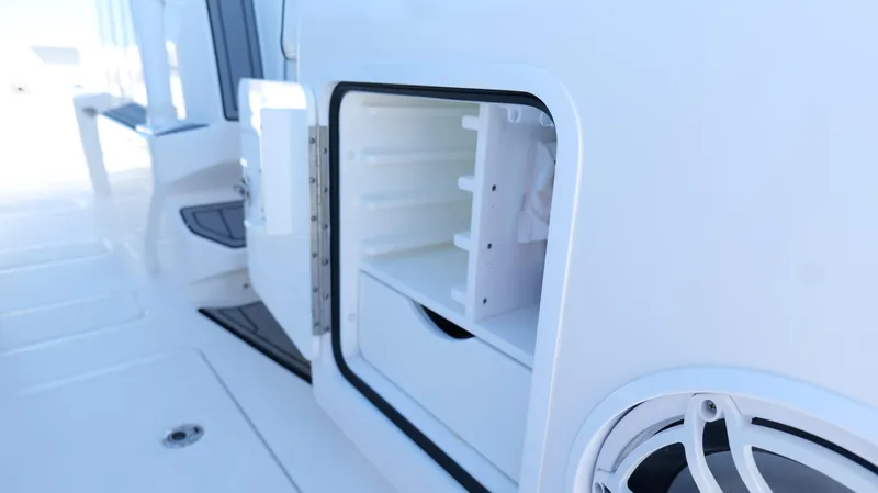 Slide: The Image of Open storage compartment on 2020 Invincible 37 Catamaran, showcasing interior shelves and speaker. - 20